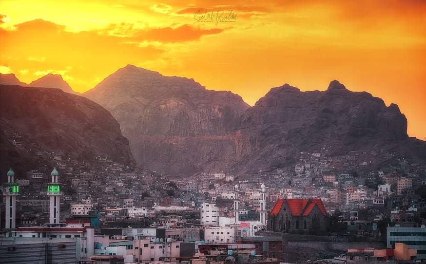 للمصور / عبدالله باحليس – تظهر لنا بيوت عدن الجميلة وخلفها الجبال الشاهقة ثم الغروب