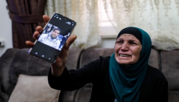 والدة الشاب الذي قتلته الشرطة الإسرائيلية تعرض صورته على هاتفها