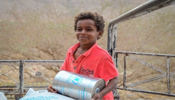 طفل يمني يتسلم مساعدات