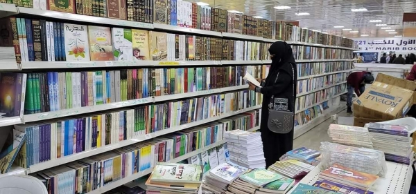 سيدة يمنية تتصفح الكتب في معرض مأرب الأول للكتاب