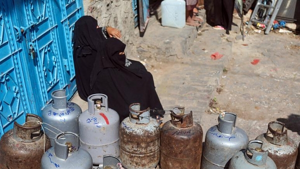 امرأة تنتظر لملء أسطوانة الغاز وسط نقص شديد في مدينة تعز اليمنية   -