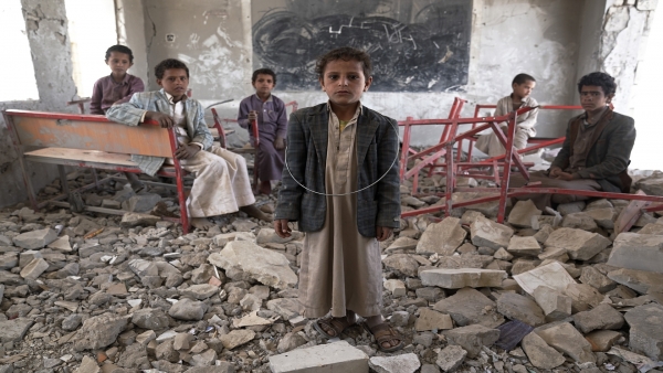 أطفال يقفون على أنقاض مبنى تم تدميره