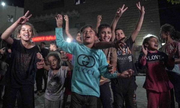 أطفال فلسطينيون يحتفلون في دير البلح، وسط قطاع غزة، بعد أن أعلنت حماس قبولها اقتراح الهدنة