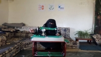 امرأة يمنية تعمل في صناعة الكمامات الطبية في المنزل